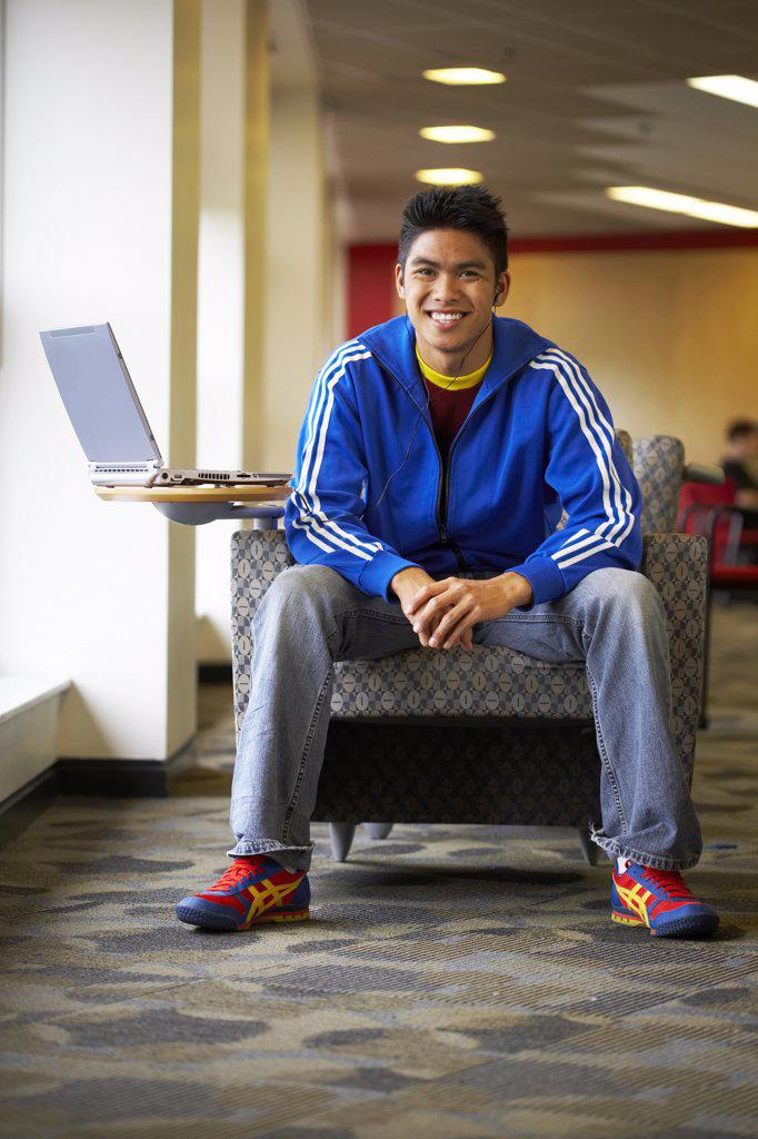 College student sitting in an armchair and smiling