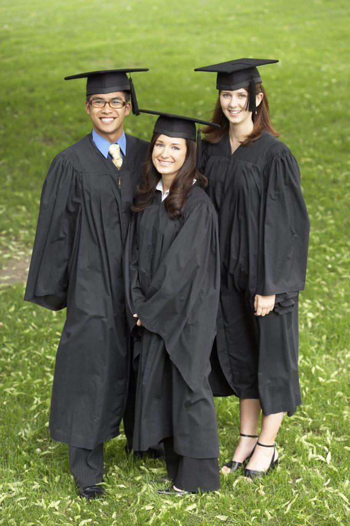 Two female graduates and a male graduate smiling