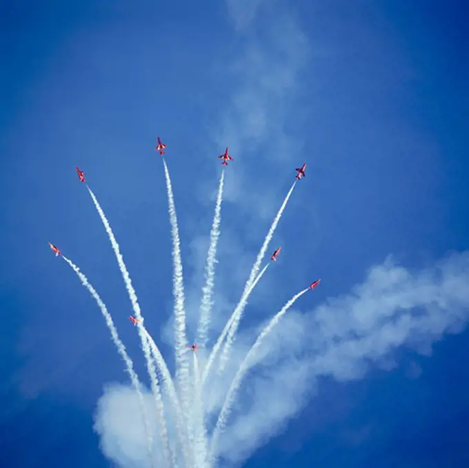Low angle view of fighter planes performing aerobatics in sky, Red Arrows, Royal Air Force, England