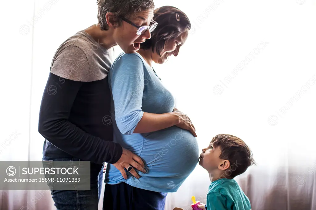 Lesbian couple with son standing by window