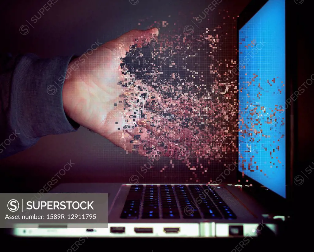 Pixelated hand of Caucasian man dissolving into laptop screen
