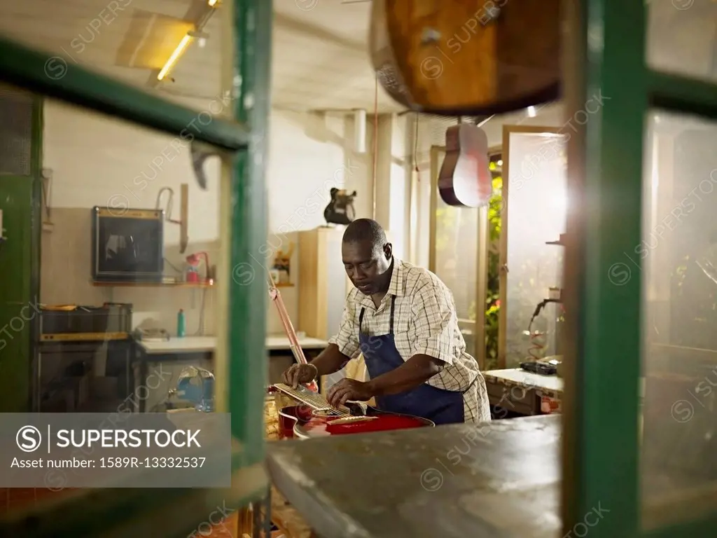Black lute maker working in workshop