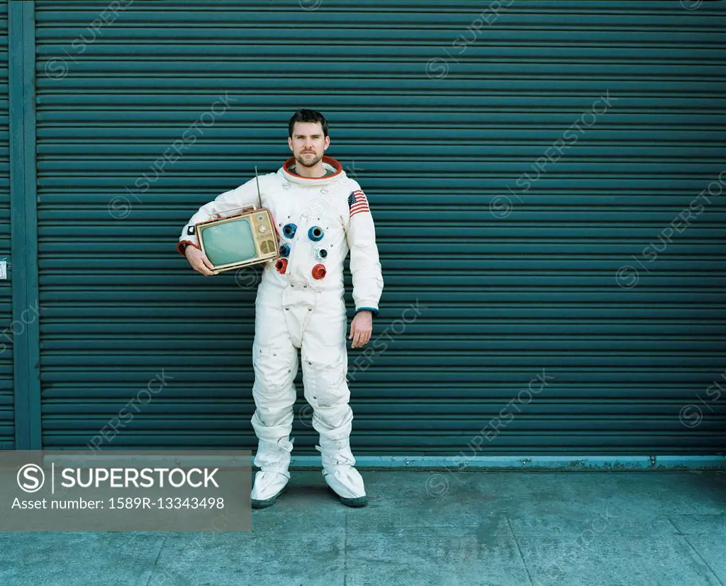 Astronaut carrying television on city street
