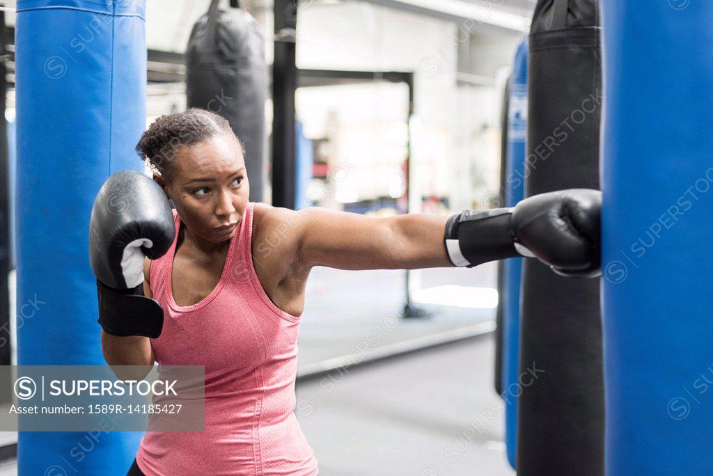 Closeup of African female athlete boxer in boxing red gloves performing a  twine on the
