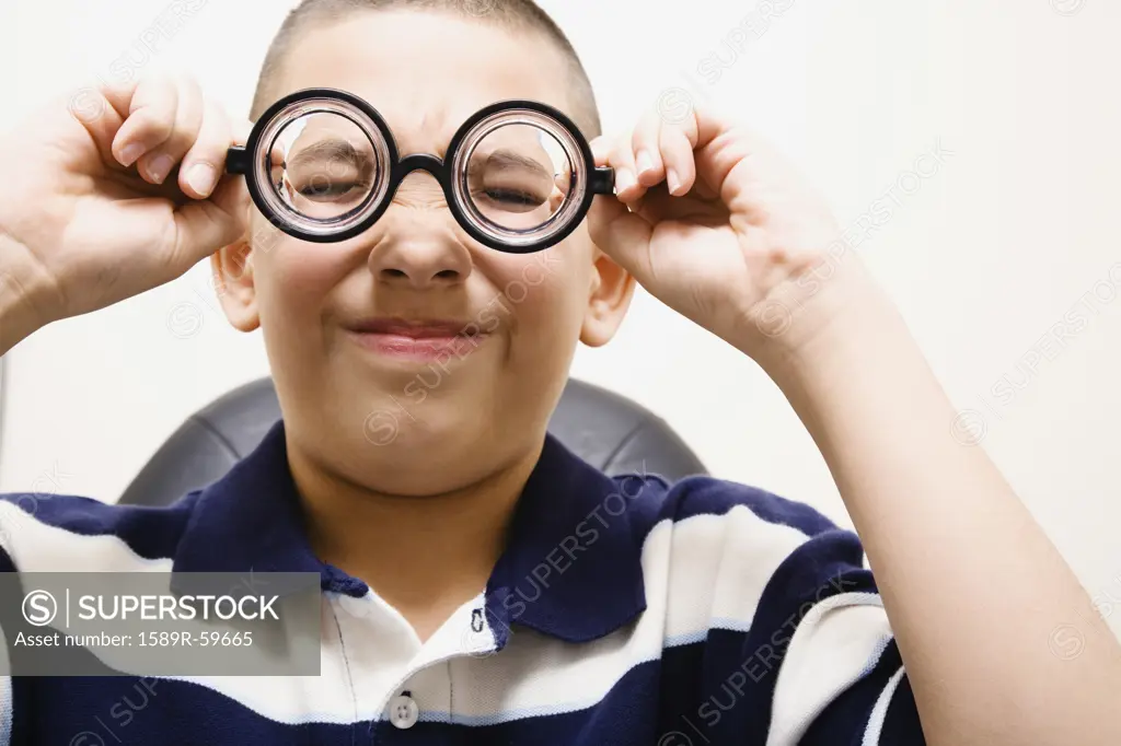 Asian boy taking off eye glasses