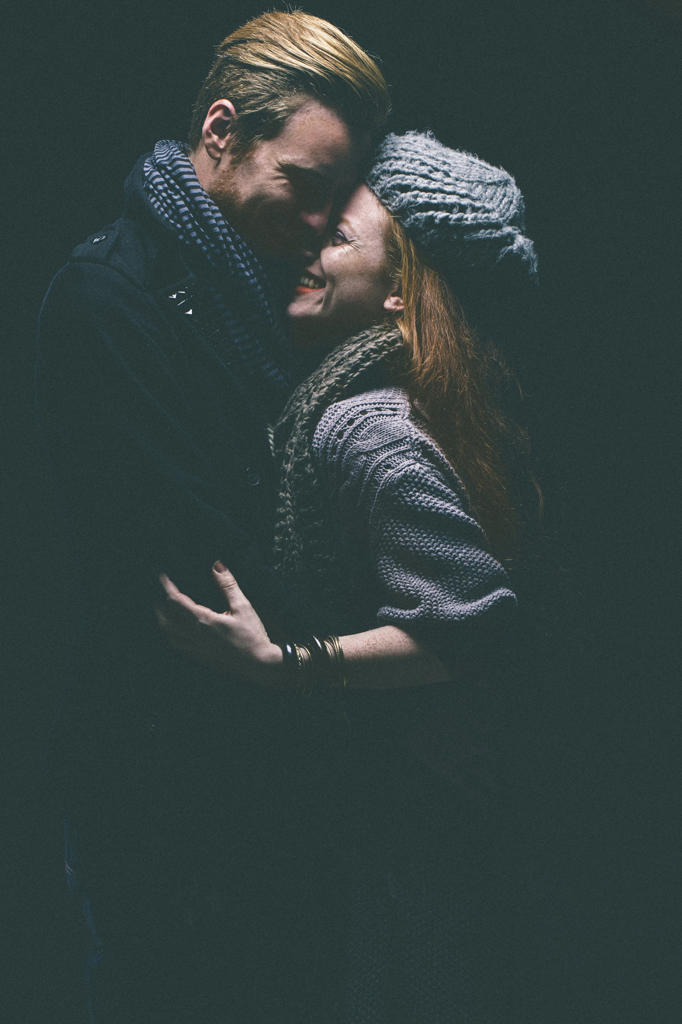 Smiling couple wearing warm clothing hugging