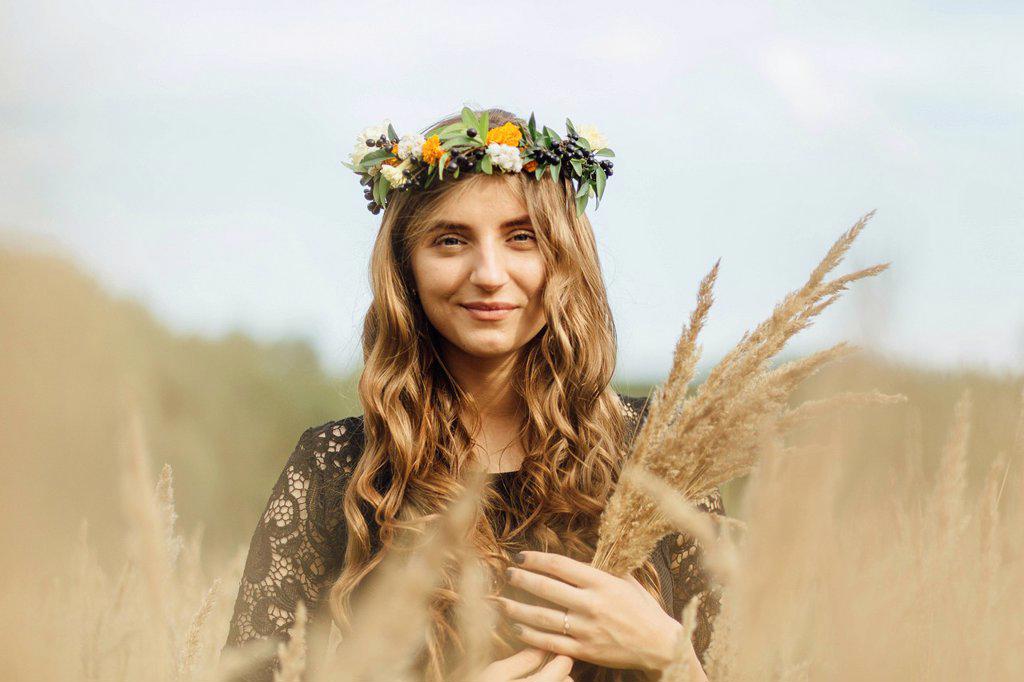 Middle Eastern woman wearing flower crown holding wheat