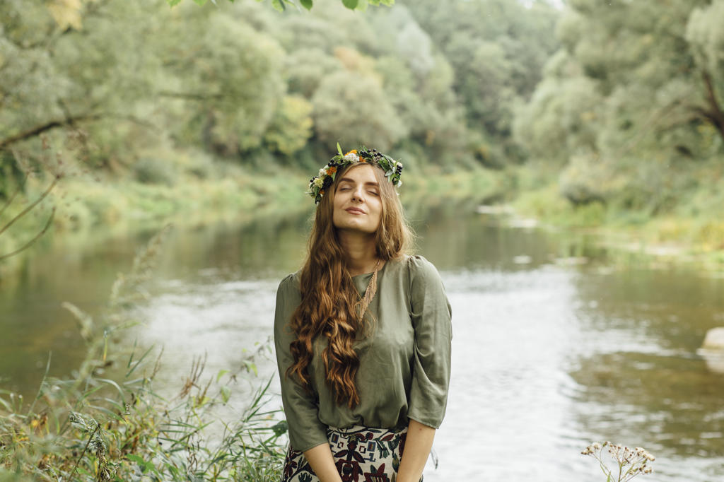 Middle Eastern woman wearing flower crown near river