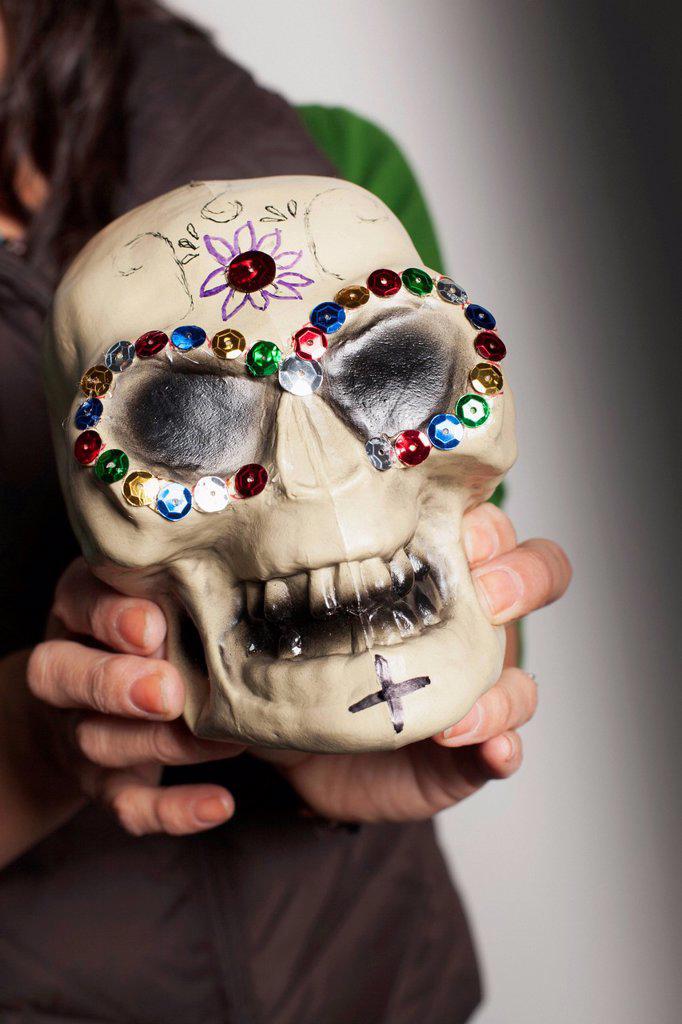 Hispanic artist holding Dia de los Muertos skull