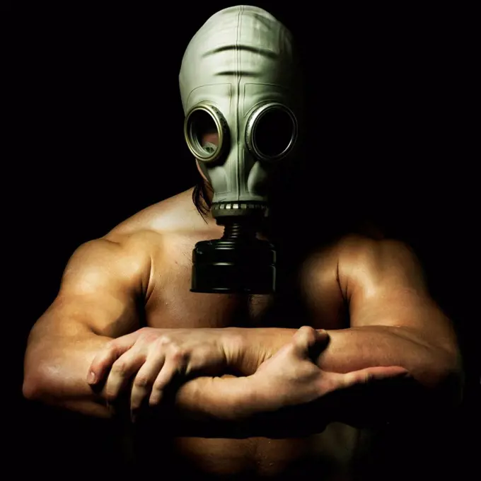 Nude Caucasian man wearing gas mask
