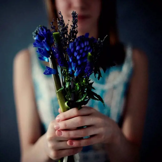 Caucasian teenage girl holding bouquet of flowers