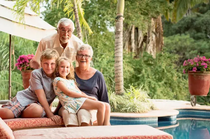 Older Caucasian couple and grandchildren smiling outdoors