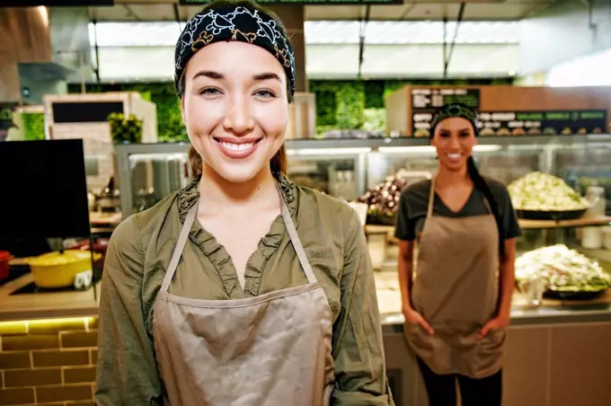 Portrait of smiling Mixed Race workers in food court