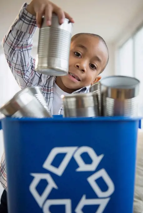 African American boy recycling aluminum cans