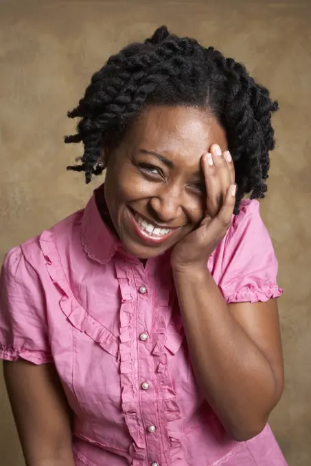 African woman laughing with hand on face