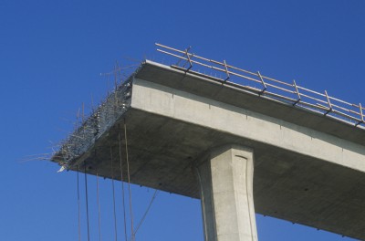 A concrete freeway structure ends abruptly with iron support structures sticking out and safety rails lining the top edge until further construction is continued, USA  - stock photo
