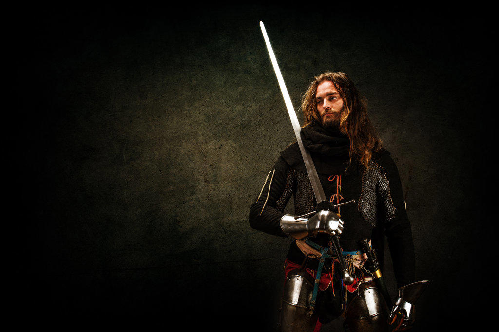 Portrait of a Knight "on guard" in studio on black background.