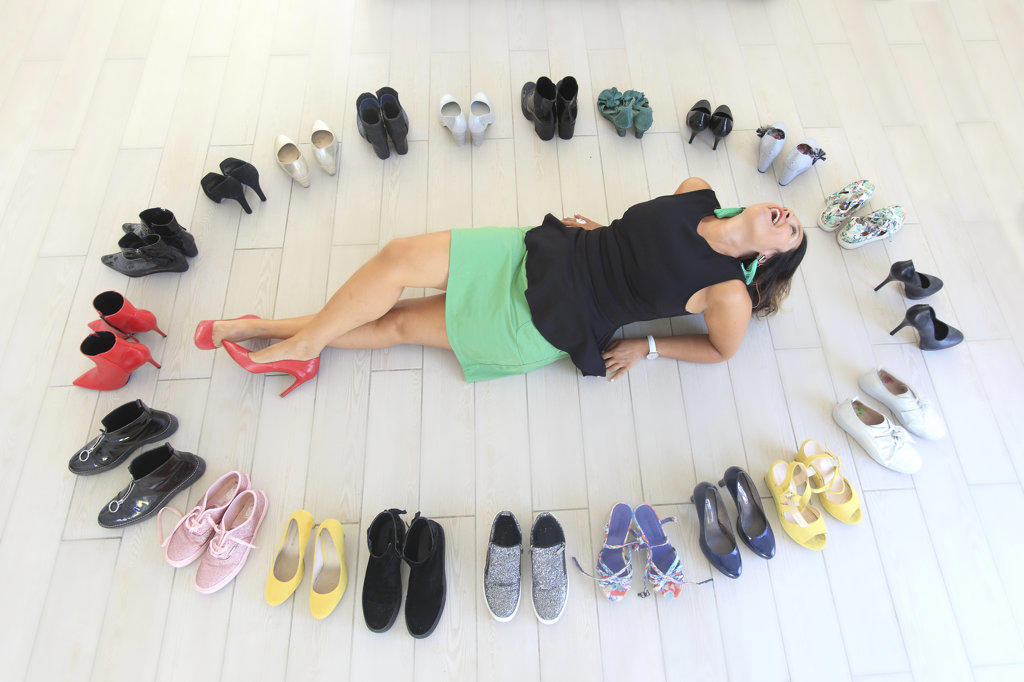 Brunette woman at her home surrounded by shoes.