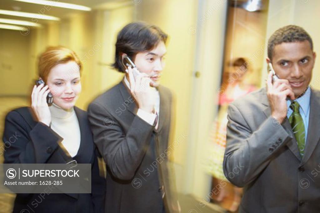 Stock Photo: 1628-285 Close-up of two businessmen with a businesswoman talking on mobile phones