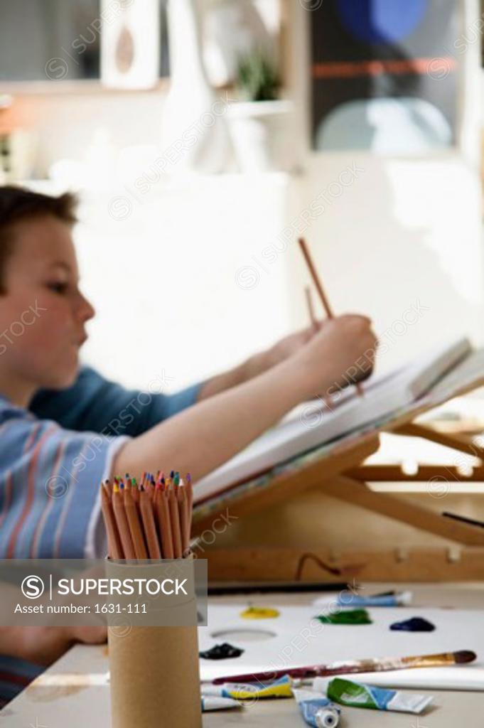 Stock Photo: 1631-111 Side profile of a boy drawing on a sketch pad
