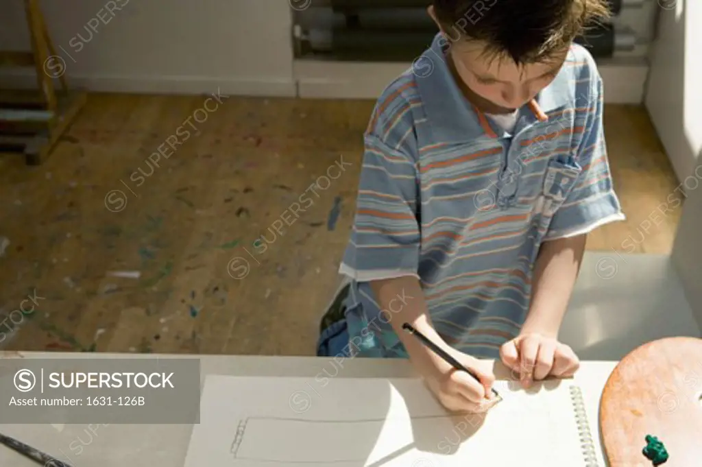 High angle view of a boy drawing on a sketch pad