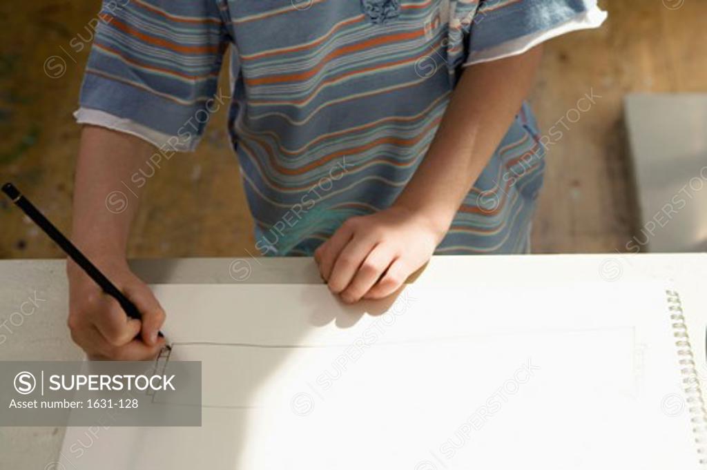 Stock Photo: 1631-128 Mid section view of a boy drawing on a sketch pad
