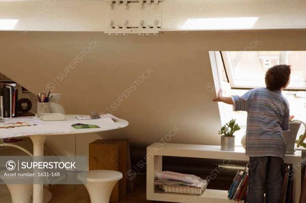 Stock Photo: 1631-148 Rear view of a boy looking through a window