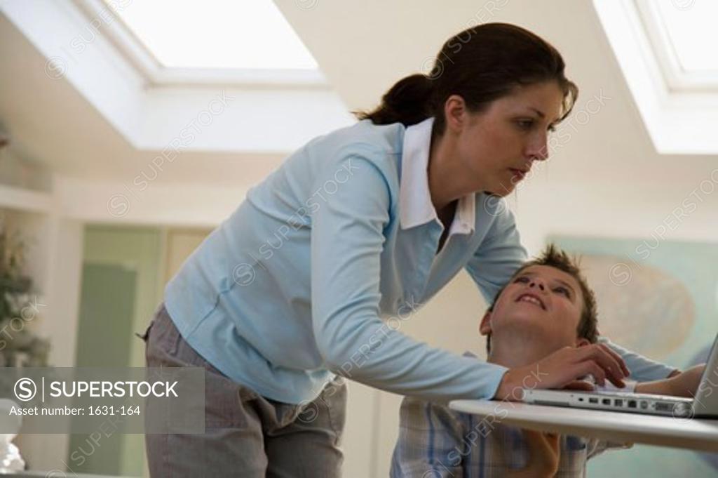 Stock Photo: 1631-164 Close-up of a young woman using a laptop with her son looking at her