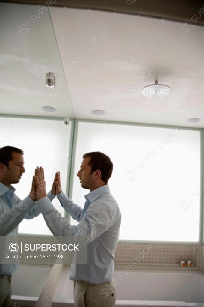 Stock Photo: 1631-198C Side profile of a young man looking in a mirror