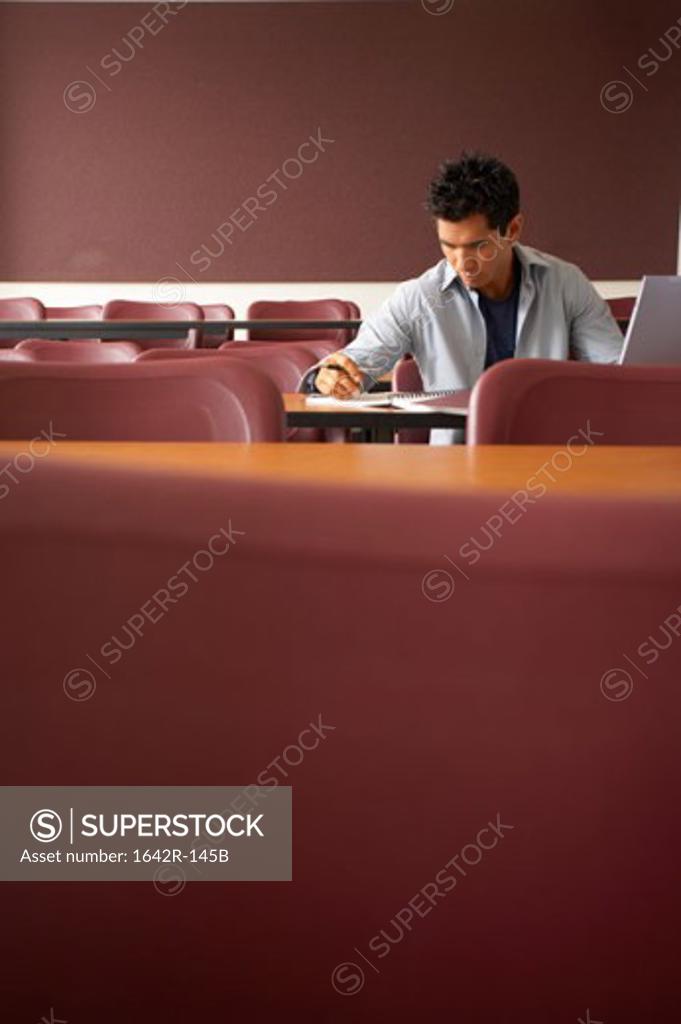 Stock Photo: 1642R-145B College student sitting in a lecture hall and studying