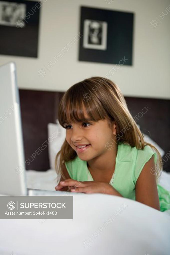 Stock Photo: 1646R-148B Close-up of a girl lying in the bed and using a laptop