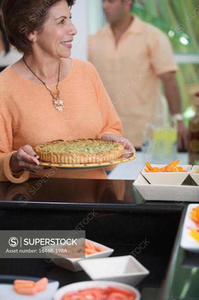 Stock Photo: 1646R-198A Mature woman holding a pie and smiling