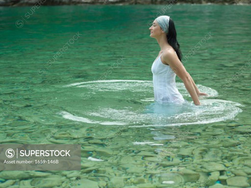 Stock Photo: 1659-146B Side profile of a young woman standing in water