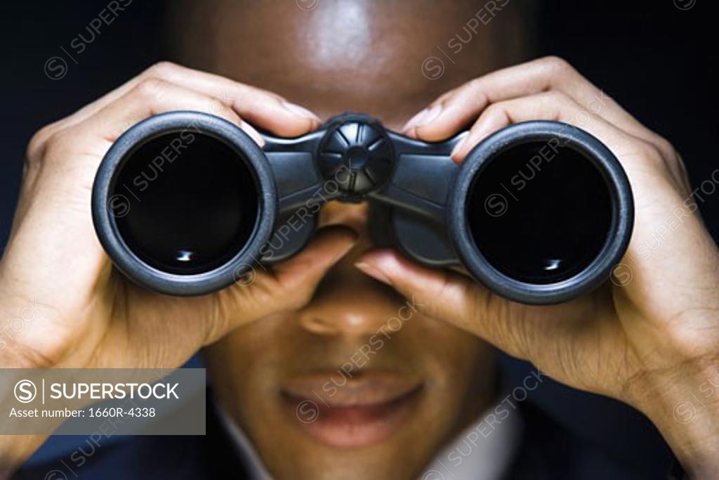 Man looking through binoculars Stock Photo 1660R4338