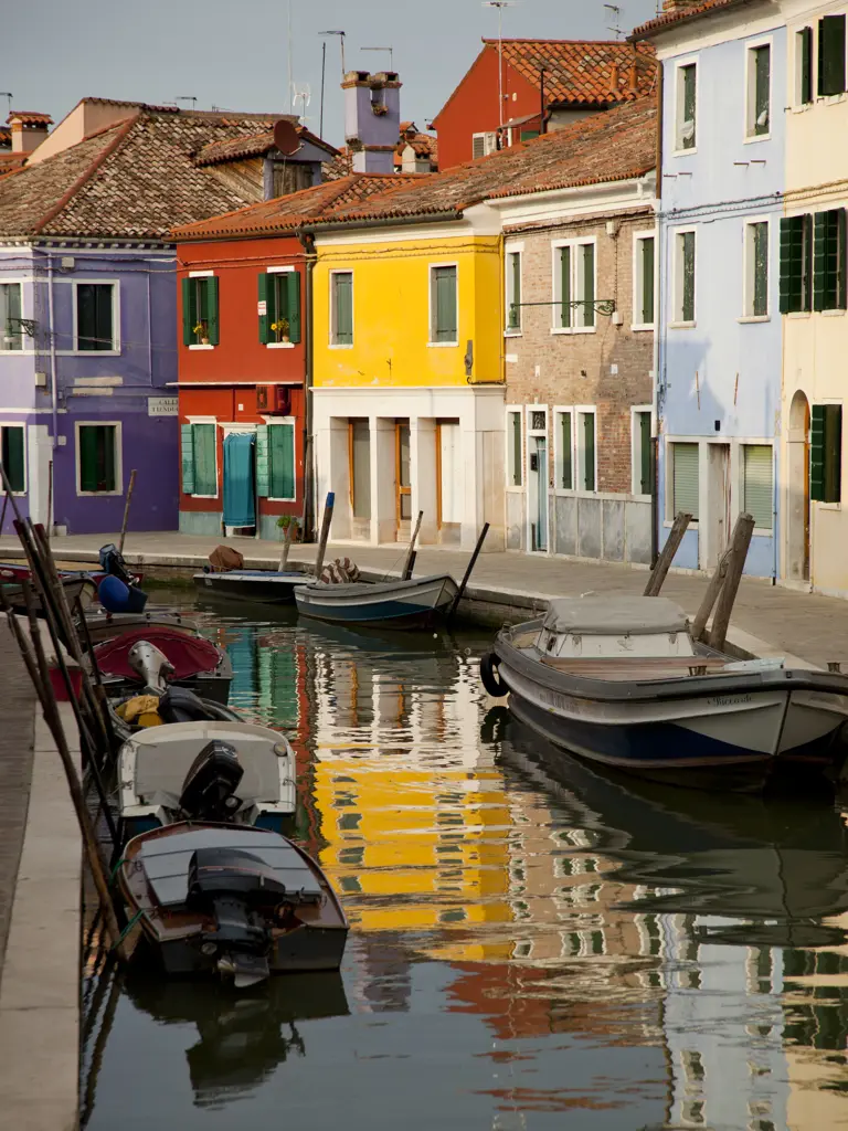 Italy, Venice, Colorful houses reflecting in canal