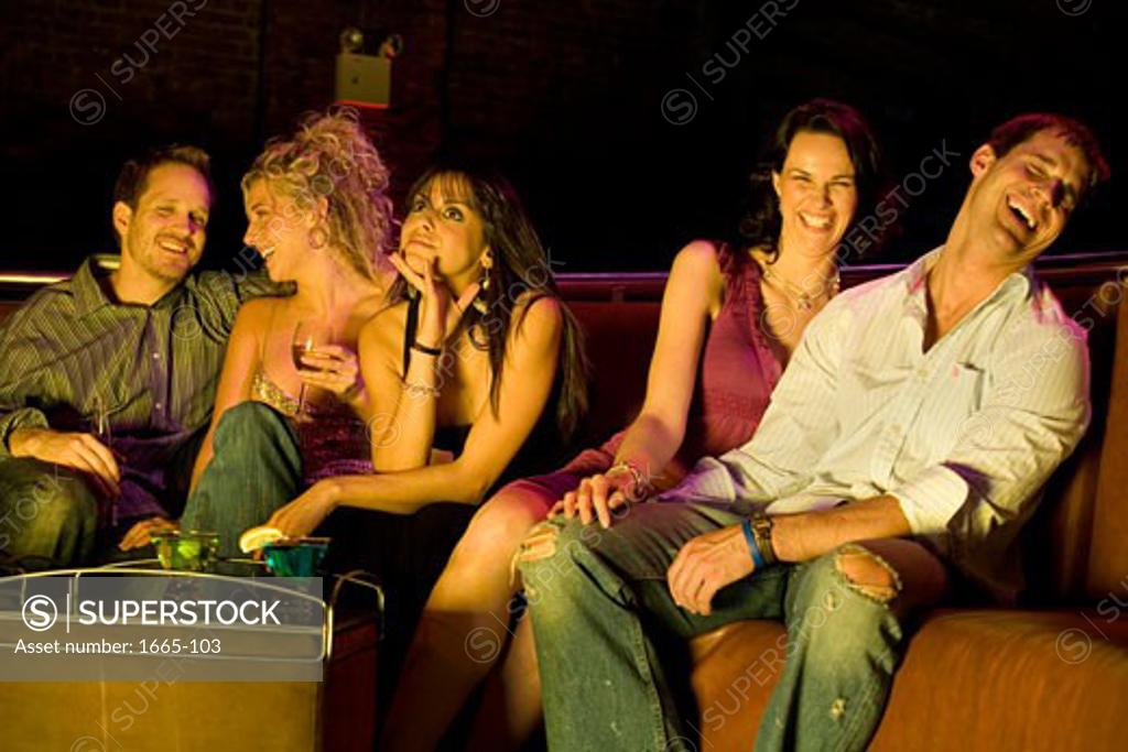 Stock Photo: 1665-103 Two young men and three young women sitting in a nightclub