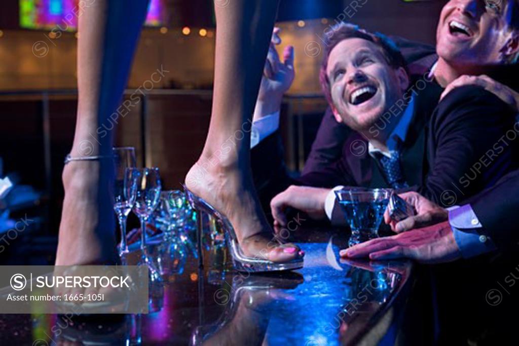 Stock Photo: 1665-105I Two young men flirting with a dancer in a nightclub