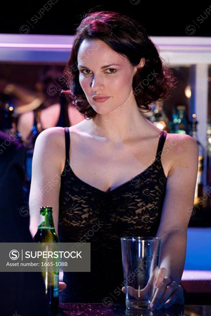 Stock Photo: 1665-108B Portrait of a female bartender holding a glass and a beer bottle
