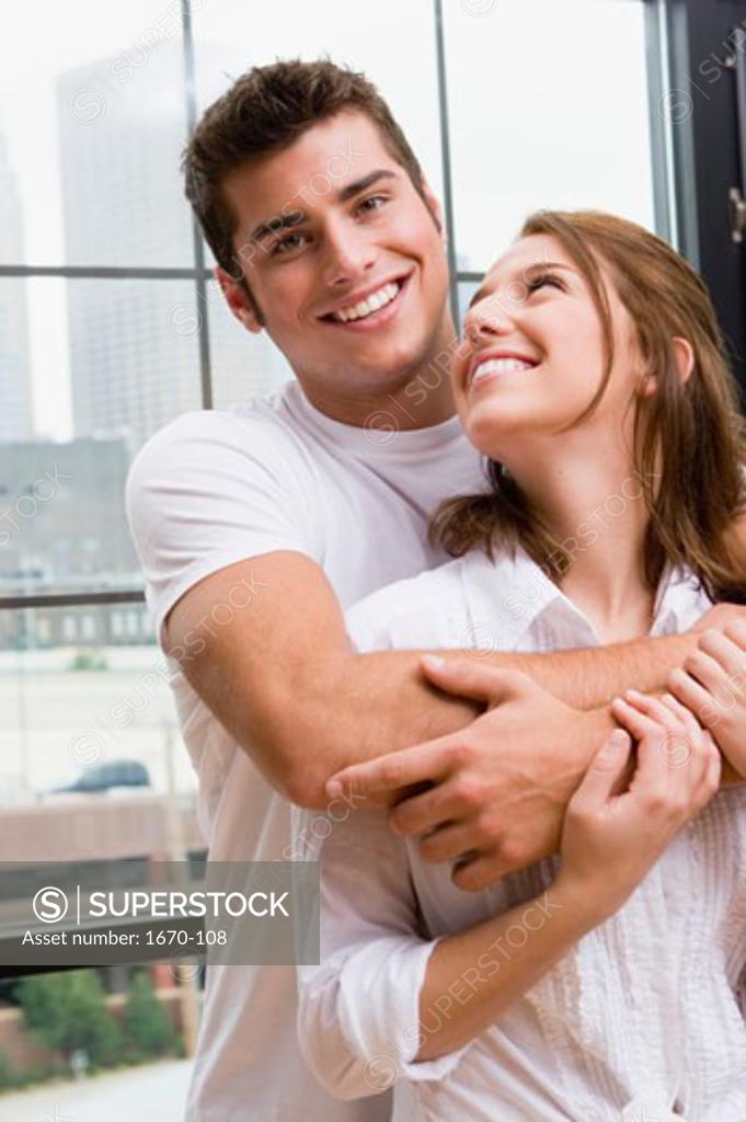 Stock Photo: 1670-108 Teenage boy embracing a young woman from behind