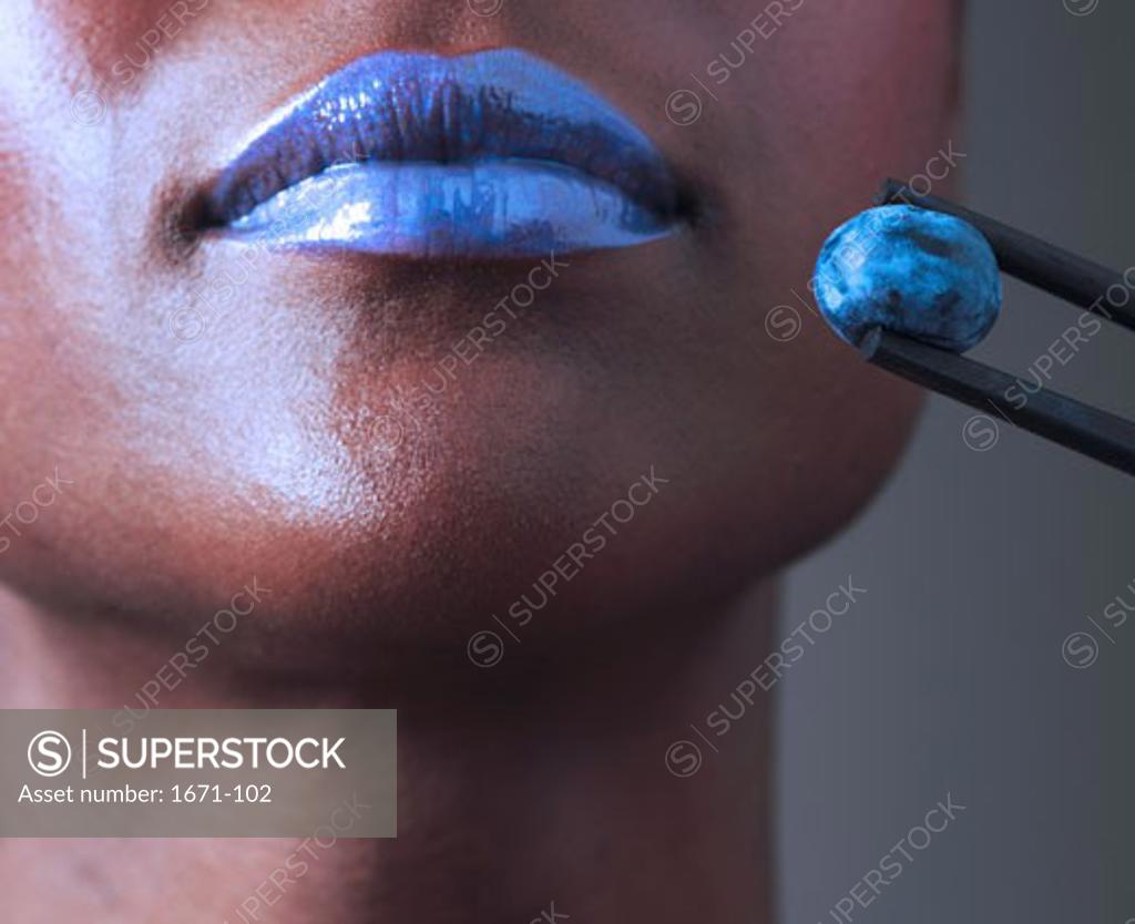 Stock Photo: 1671-102 Close-up of a young woman with a blueberry near her mouth