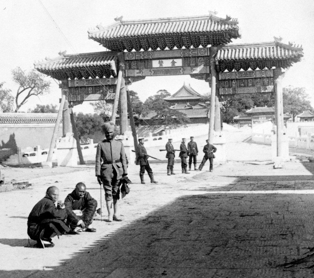 east over Marble Bridge toward the Forbidden City, Peking, 1901. photographic print on stereo card, Indian soldiers and two Chinese men in front of a gate.