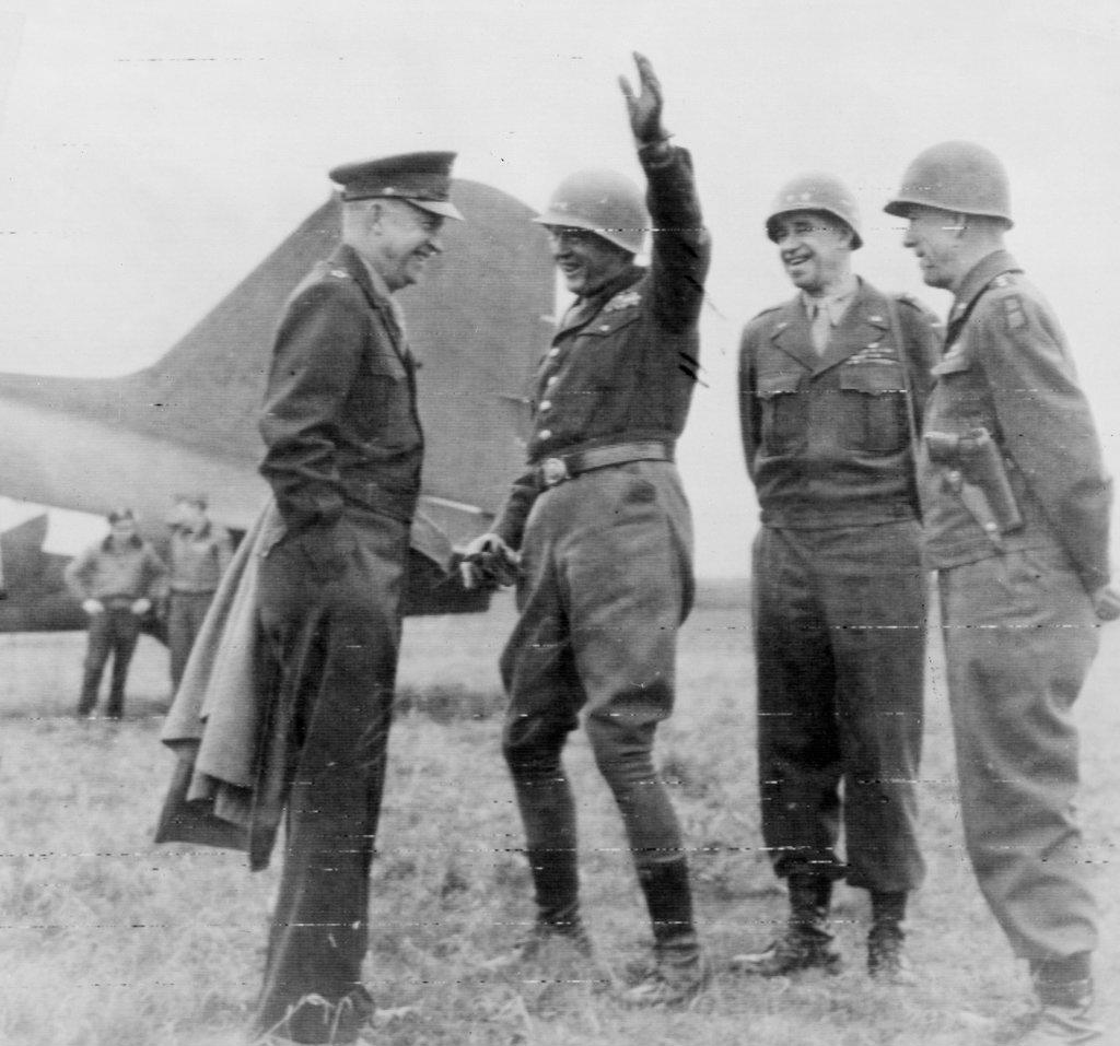 Photograph shows General Eisenhower meeting with generals Patton, Bradley, and Hodges on an airfield somewhere in Germany. Dated 1945