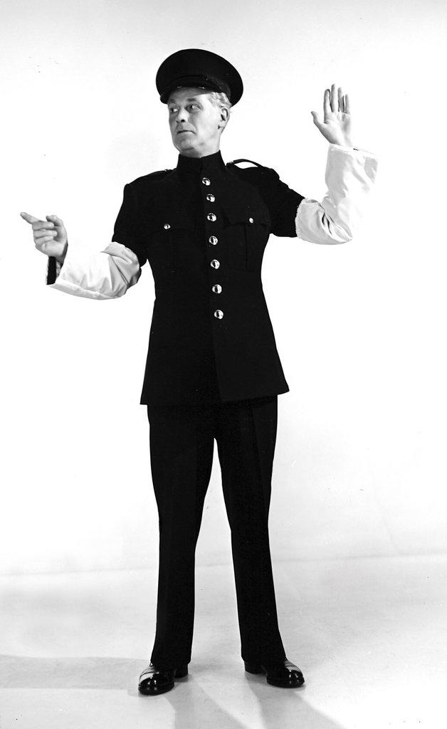 Police uniform produced from a wool/nylon blend, by H. Lottery & co. Ltd. The garment is designed for use by works police patrolmen and transport personnel. The white traffic sleeves are made entirely from continuous filament nylon. 1956