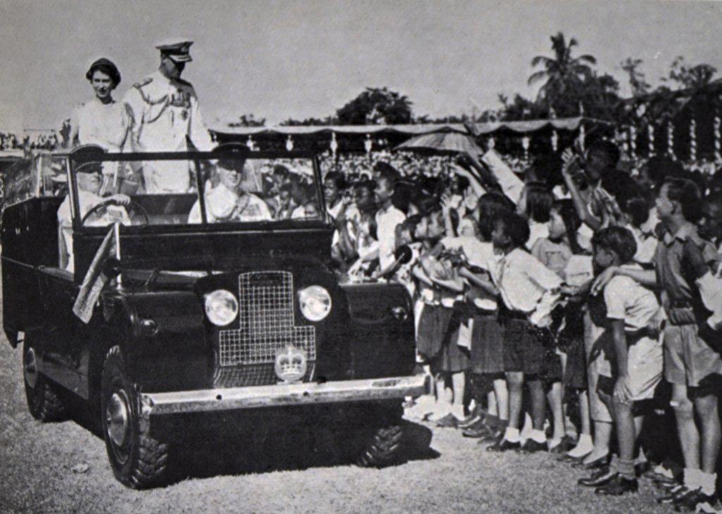 Photograph of Queen Elizabeth II (1926-) and Prince Philip (1952-) in an open-top car riding through Sabina Park, Kingston, Jamaica. Dated 20th Century