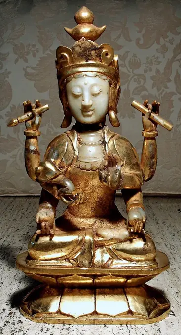 Ancient China: Gilt Jade figure of the compassionate deity, Kwan Yin, Eastern Han Dynasty, 24-220 AD. Holding the implements of power in six arms.
