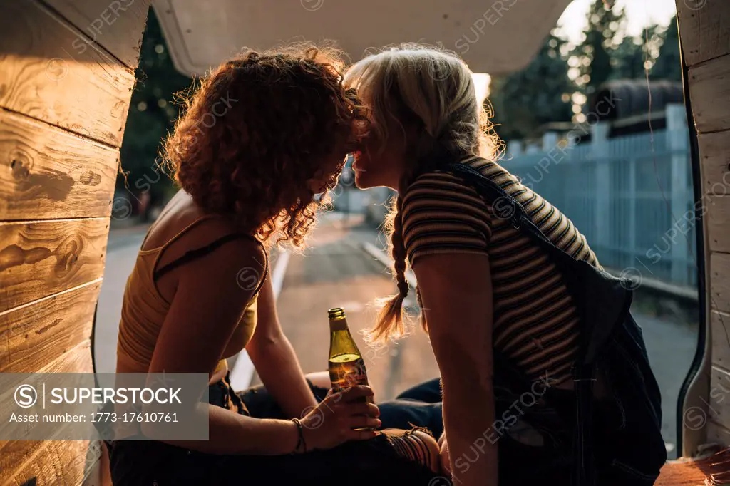 Young lesbian couple sharing kiss in the back of their van