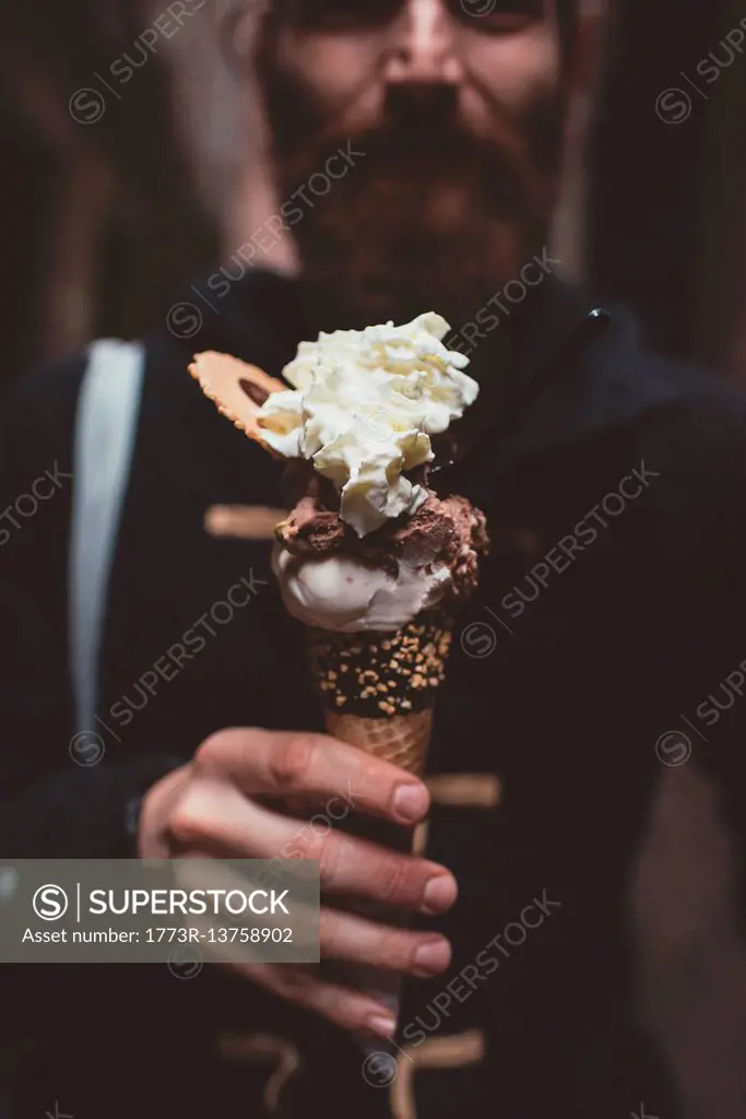 Hand of man holding gelato in dark alley, Venice, Italy