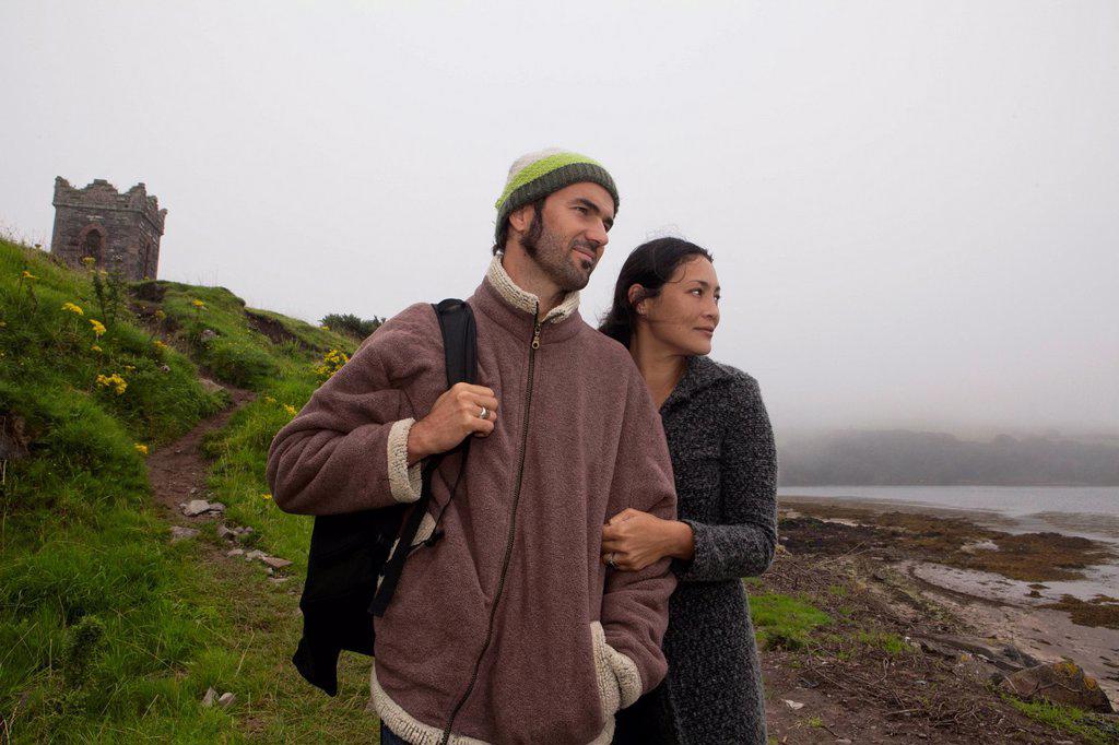 Mid adult couple strolling on misty coast, Dingle Peninsula, Ireland