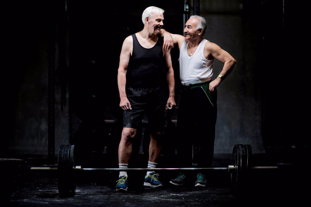 Senior men chatting in dark gym