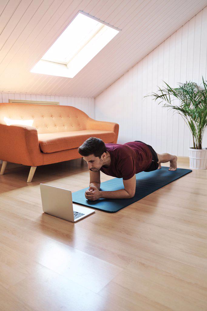 Man following exercise class on laptop